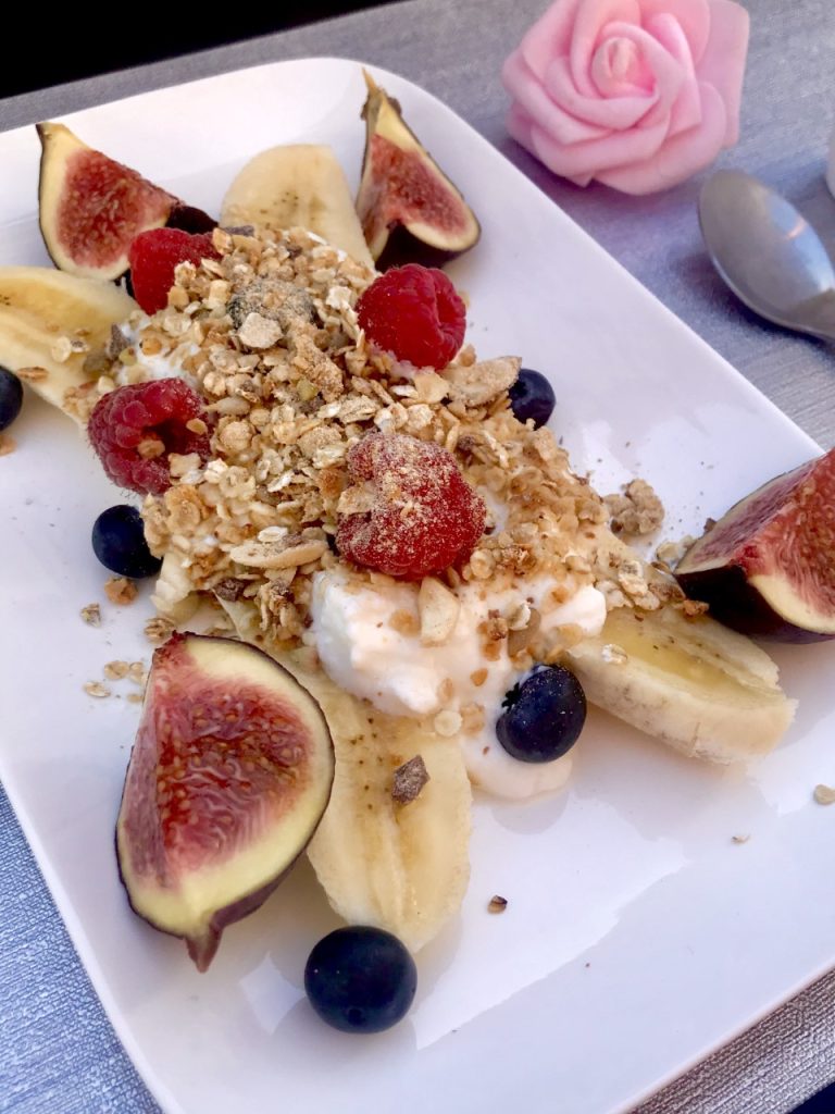 une banane découpée garnies de yaourt, de fruits de saison au choix et de granola maison